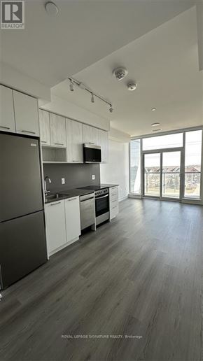 Brampton (Northwest Brampton) condo for rent - A modern kitchen with a refrigerator, cabinets, and a countertop.