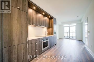 Toronto (Dovercourt-Wallace Emerson-Junction) condo for rent - A modern kitchen with wooden cabinets and a large window.