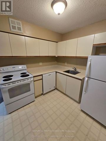 London North (North G) condo for rent - A kitchen with white appliances and brown cabinets.