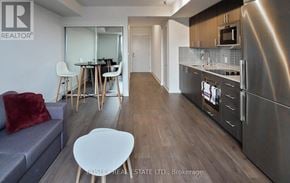 Oshawa (Windfields) house for rent - A modern kitchen with stainless steel appliances and a dining area with a table and chairs.