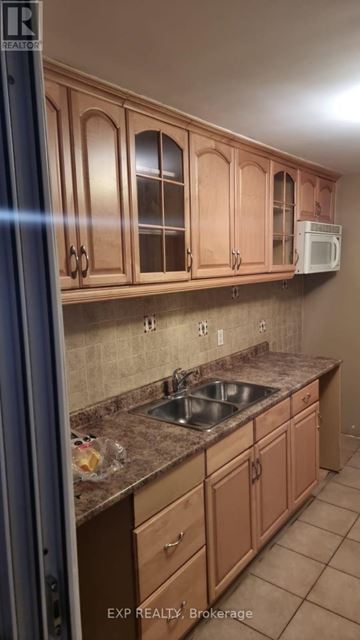 Toronto (Rockcliffe-Smythe) apartment for rent - A kitchen with brown cabinets and a sink.