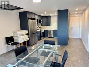Prince Edward County (South Marysburgh) apartment for rent - A modern kitchen with a glass table and stainless steel appliances.