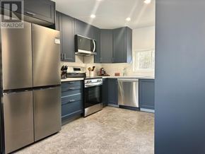 Prince Edward County (South Marysburgh) apartment for rent - A kitchen with a refrigerator, oven, and sink.