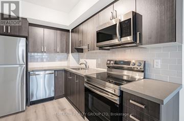 Toronto (Yorkdale-Glen Park) condo for rent - A modern kitchen with dark wood cabinets and stainless steel appliances.