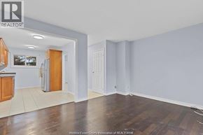 Windsor townhouse for rent - A room with wooden floors and white walls, with a kitchen area visible in the background.