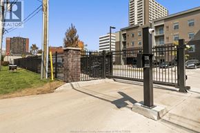 Windsor condo for rent - A black metal fence with a yellow gate is in front of a brick wall.