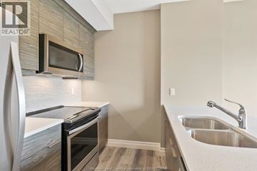 Windsor condo for rent - A modern kitchen with a stainless steel oven and microwave.