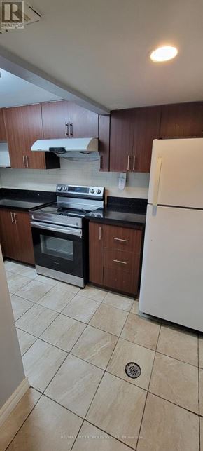 Toronto (Bendale) apartment for rent - A kitchen with white appliances and brown cabinets.