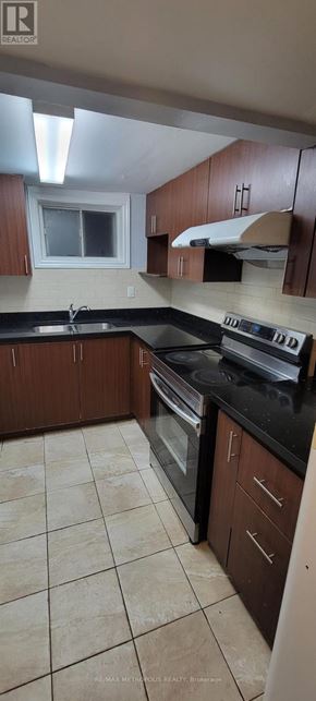 Toronto (Bendale) apartment for rent - A kitchen with brown cabinets and black countertops.