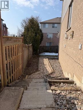 Aurora (Aurora Grove) townhouse for rent - A backyard with a wooden fence and a brick pathway.