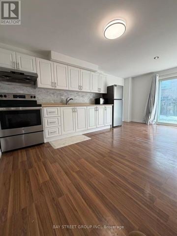 Aurora (Aurora Grove) townhouse for rent - A kitchen with wooden floors and white cabinets.