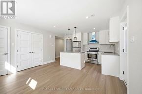 Ottawa apartment for rent - A white kitchen with wooden floors and a white ceiling.