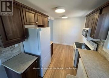 Toronto (Willowdale West) apartment for rent - A kitchen with brown cabinets and a white refrigerator.