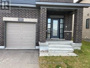 Ottawa townhouse for rent - A house with a grey garage door and a glass door entrance.