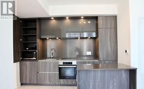 Toronto (Waterfront Communities) condo for rent - A modern kitchen with a stainless steel oven and wooden cabinets.