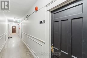 Ottawa apartment for rent - A hallway with a door on the right and a broom on the floor.