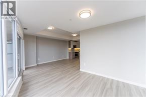 Hamilton condo for rent - A spacious room with wooden flooring and a large window on the left side.