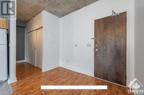 Ottawa condo for rent - A room with a wooden floor and a large wooden door.