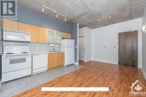 Ottawa condo for rent - A kitchen with white appliances and wooden cabinets is on the market.
