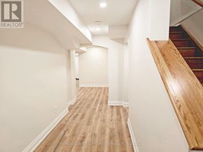 St. Catharines (Haig) apartment for rent - A hallway with wooden floors and a staircase on the right.