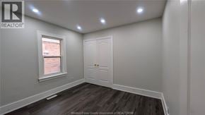 Windsor apartment for rent - A room with a white door and a window with a view of a brick building outside.