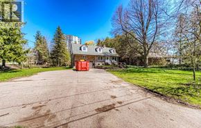 Waterloo apartment for rent - A house with a red door is surrounded by trees and grass.