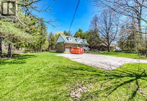 Waterloo apartment for rent - A house with a red garage door is surrounded by trees and grass.