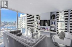 Vancouver apartment for rent - A living room with a grey sofa and a view of the city.
