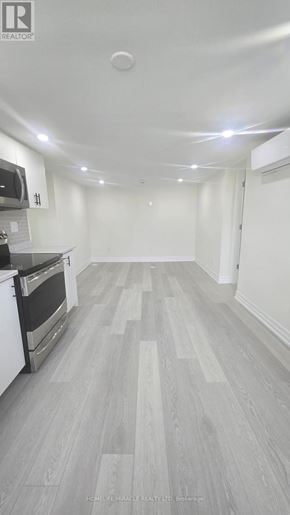 Oshawa (Donevan) apartment for rent - A spacious kitchen with a stove top oven and a microwave.