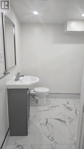 Oshawa (Donevan) apartment for rent - A white toilet sits next to a sink in a small bathroom.