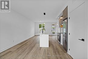 Ottawa apartment for rent - A realtor photo of a kitchen with a white island in the middle.