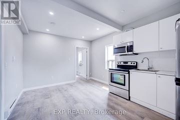 Toronto (Playter Estates-Danforth) multi-family for rent - A kitchen with white cabinets and a stainless steel oven.