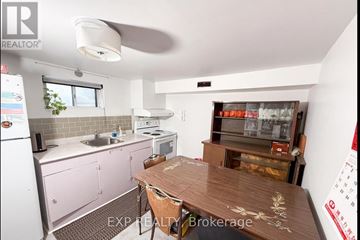 Toronto (Newtonbrook West) apartment for rent - A kitchen with pink cabinets and a wooden table.