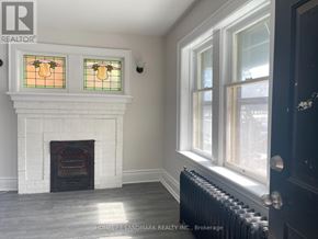 Hamilton (Crown Point) multi-family for rent - A room with a fireplace and a window with a stained glass design.