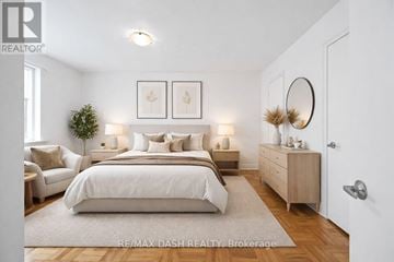 Toronto (Stonegate-Queensway) multi-family for rent - A bedroom with a large bed, a couch, and a dresser with a mirror.