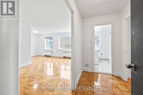 Toronto (Stonegate-Queensway) multi-family for rent - A room with wooden floors and white walls, with a door on the right side.