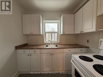 Toronto (Stonegate-Queensway) multi-family for rent - A kitchen with white cabinets and a marble countertop.