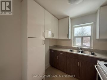 Toronto (Stonegate-Queensway) multi-family for rent - A kitchen with white cabinets and a window.