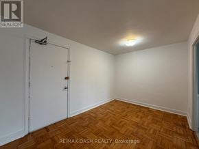 Toronto (Stonegate-Queensway) multi-family for rent - A room with a wooden floor and a white door.