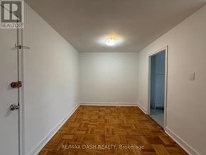 Toronto (Stonegate-Queensway) multi-family for rent - A room with a wooden floor and a door on the left side.