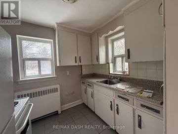 Toronto (Stonegate-Queensway) multi-family for rent - A kitchen with white cabinets and a granite countertop.