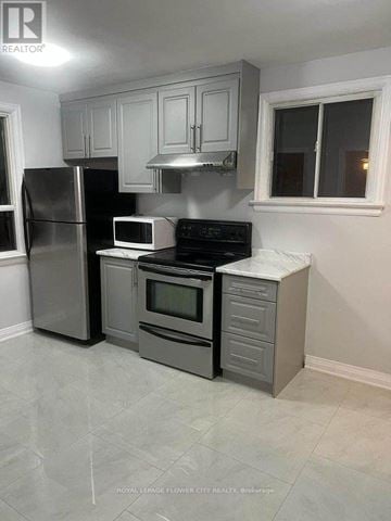 Toronto (Birchcliffe-Cliffside) apartment for rent - A kitchen with a refrigerator, microwave, oven, and cabinets.