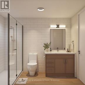 Brockville apartment for rent - A white toilet sits in a bathroom with a brown cabinet and a mirror above it.