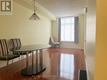 Toronto (Newtonbrook West) townhouse for rent - A living room with a glass table and striped chairs.