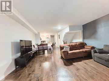 Ottawa condo for rent - A living room with a brown couch and a wooden floor.