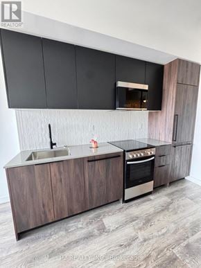 Toronto (Highland Creek) condo for rent - A modern kitchen with dark brown cabinets and a stainless steel oven.