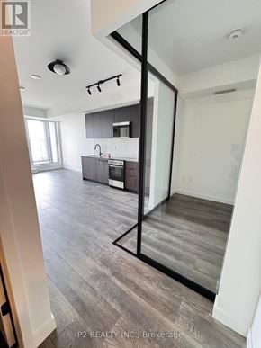 Toronto (Highland Creek) condo for rent - A modern kitchen with dark wood floors and white walls.