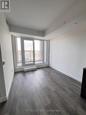 Toronto (Highland Creek) condo for rent - A room with a large window and a wooden floor.