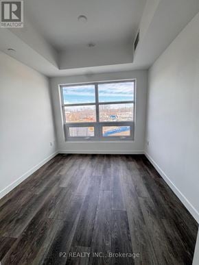 Toronto (Highland Creek) condo for rent - A room with a large window and wooden flooring.