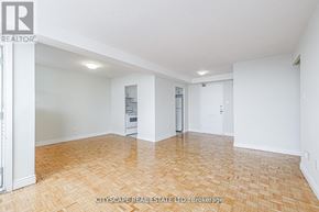 Toronto (Maple Leaf) condo for rent - A spacious room with wooden flooring and white walls.